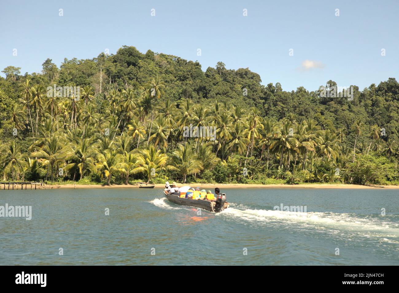 Ein Boot mit Touristen segelt auf dem Wasser vor der Küste der Insel Seram, in der Nähe des Dorfes Horale in Seram Utara Barat, Maluku Tengah, Maluku, Indonesien. Stockfoto