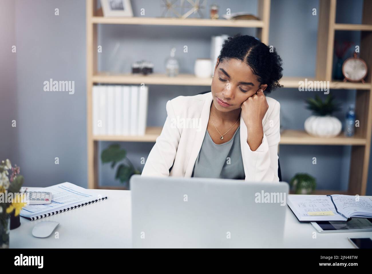 Müde, Burnout und überfordert Frau, die in einem Büro an einem Laptop arbeitete, schläfig und ein Nickerchen machte. Junge Frau, die an Müdigkeit und niedriger Energie leidet Stockfoto