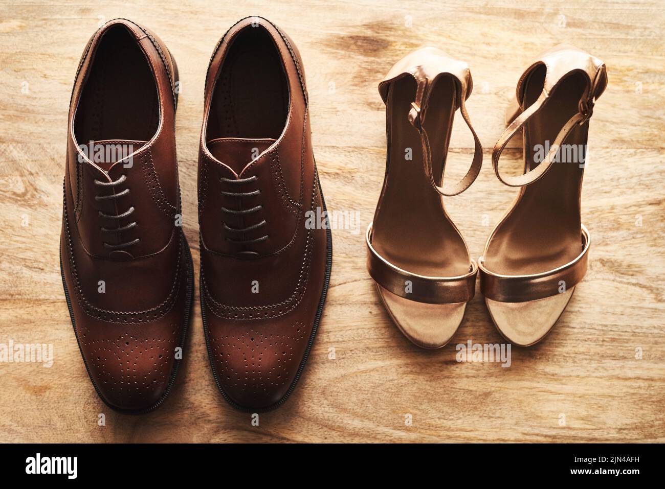 Waren bereit, den Gang hinunter zu gehen. Stillleben einer Braut und eines Bräutigams Hochzeit Schuhe nebeneinander auf einer hölzernen Oberfläche. Stockfoto