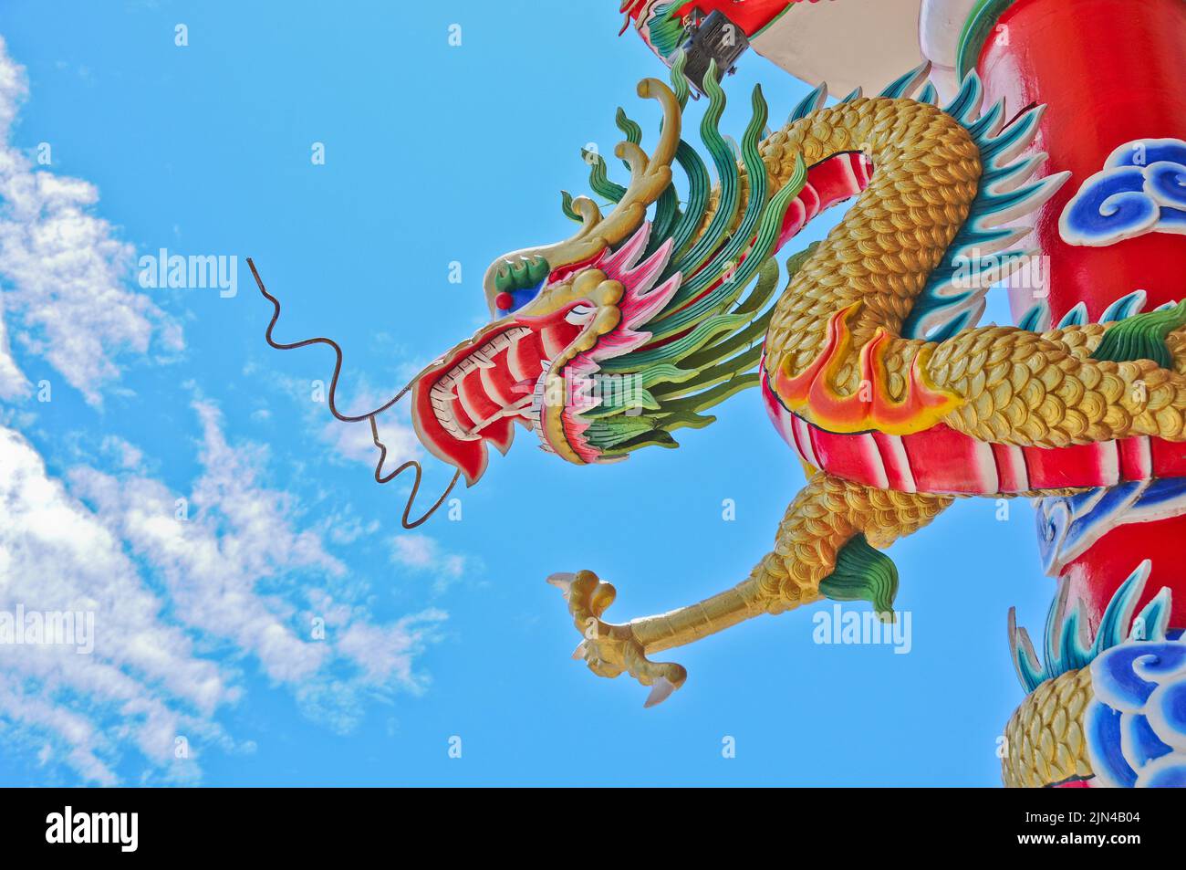 Goldene fliegende majestätische asiatische chinesische Drachenstatue mit blauem Himmel an sonnigen Tagen Stockfoto