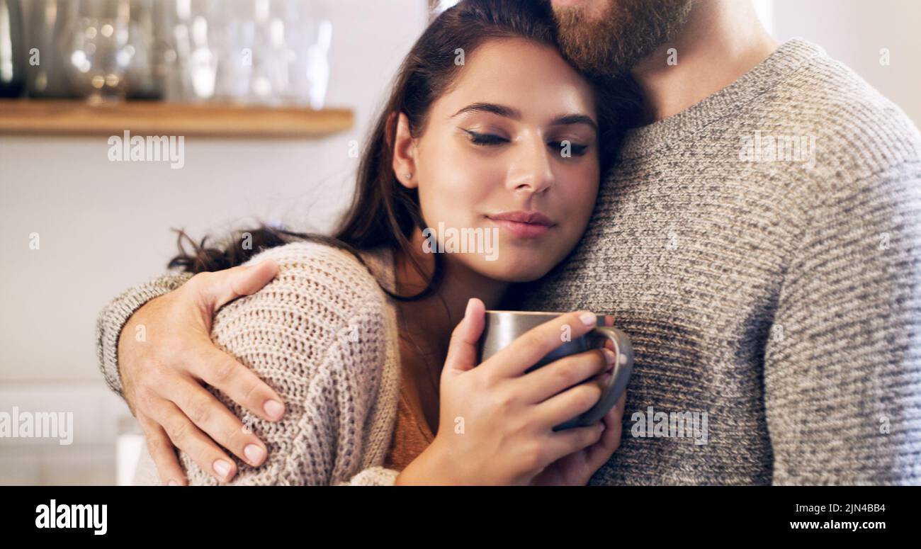 Alltägliche Momente sind manchmal das Besondere. Ein glückliches junges Paar, das in der Küche zu Hause Kaffee zusammen hat. Stockfoto