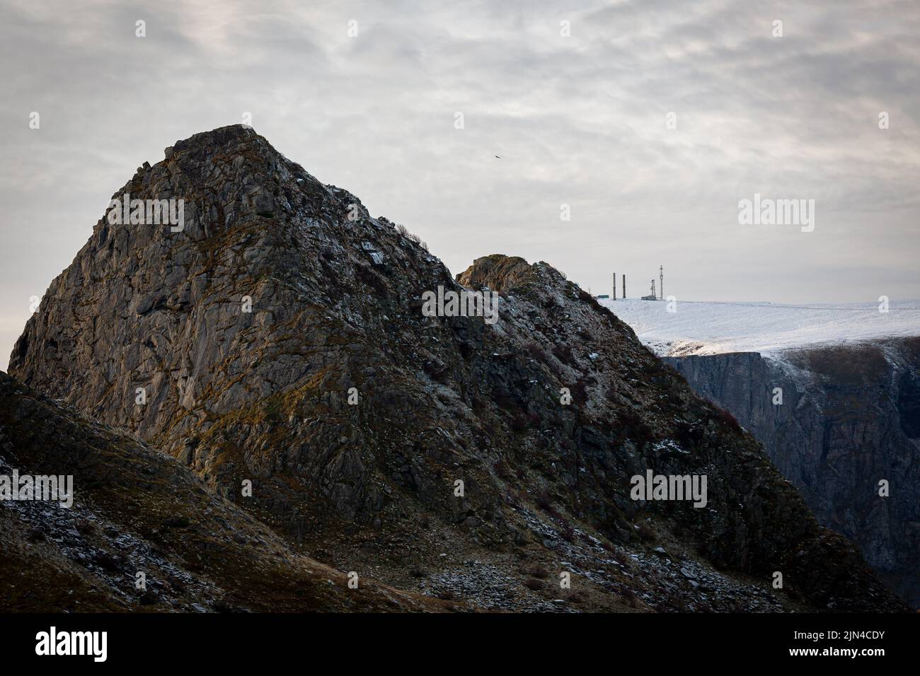 Die Landschaft der extrausive, unergrüßige Felsen und schneebedeckten Klippen unter dem wolkigen Himmel in Lofoten Stockfoto