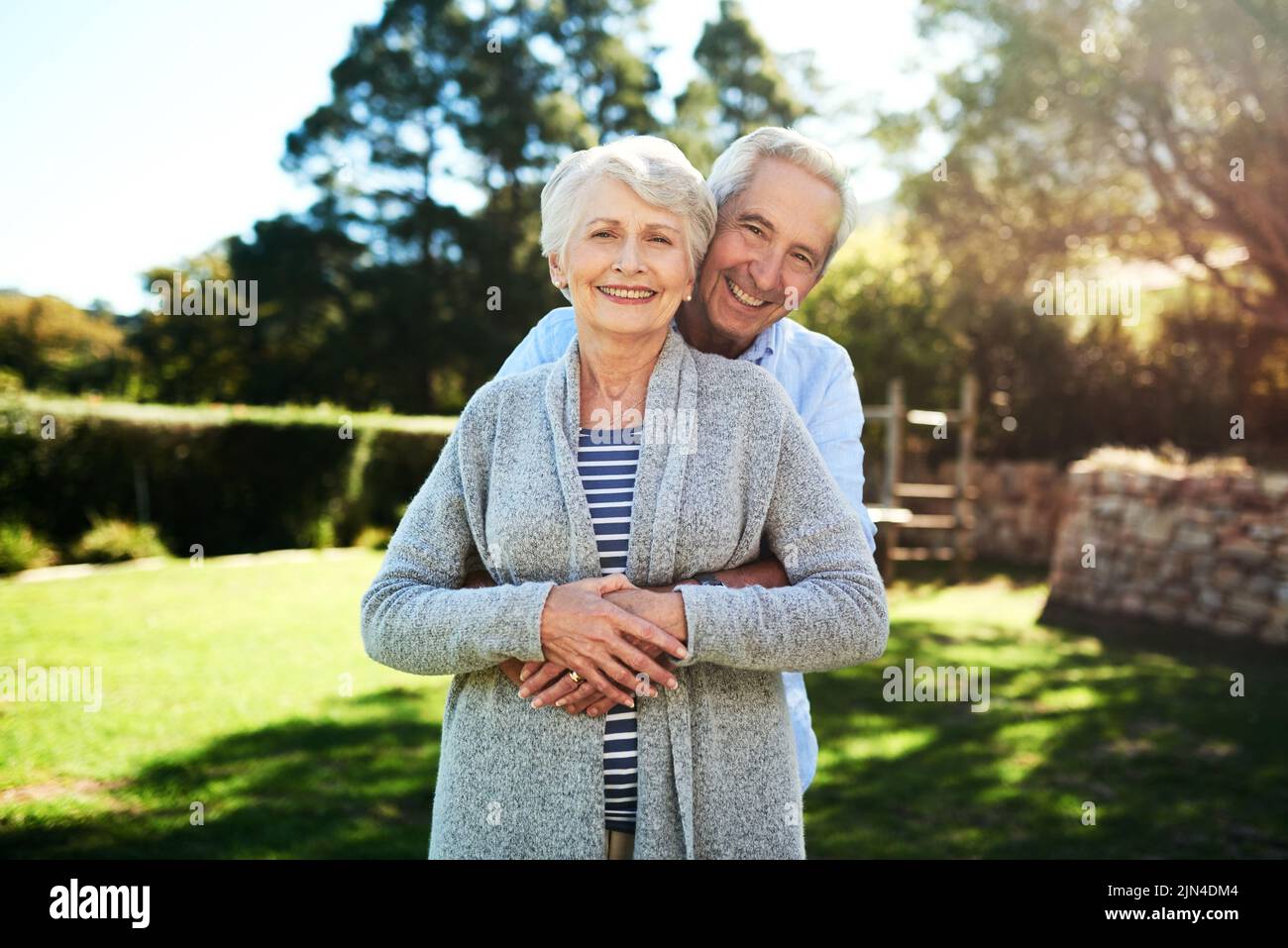 Unser Leben glücklich immer nach. Porträt eines liebevollen Seniorenpaares, das zu Hause in ihrem Hinterhof posiert. Stockfoto