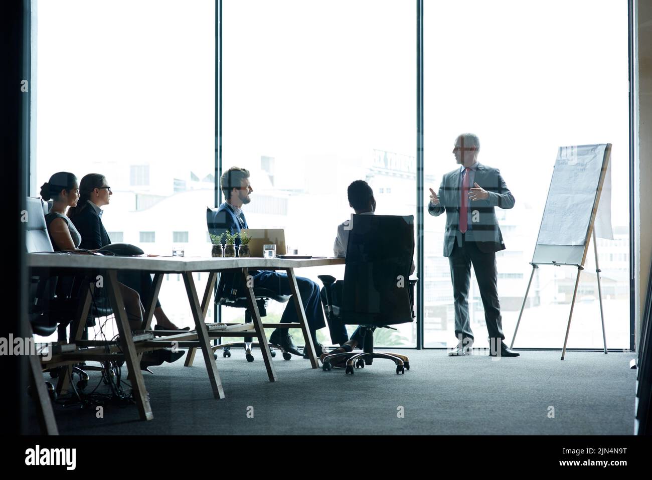 Sprechender Vorgesetzter präsentiert Strategie, denkt und motiviert ein Team von Führungskräften Ideen in einem Vorstand. Manager und Führungskraft erklären Innovation Stockfoto