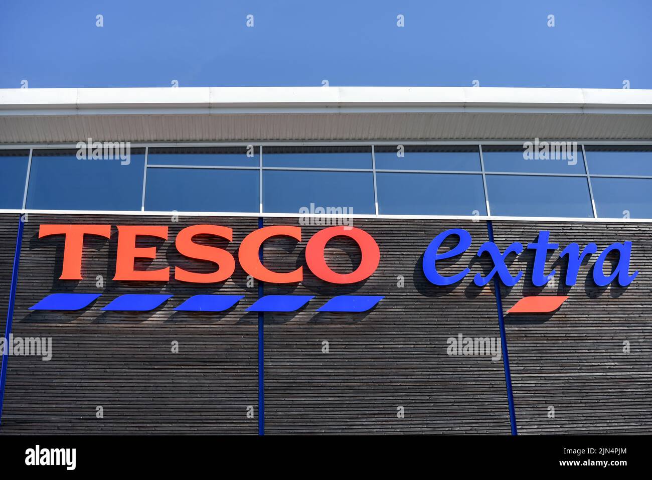 Rot und blau Tesco extra Zeichen der Seite eines modernen Gebäudes. Stockfoto