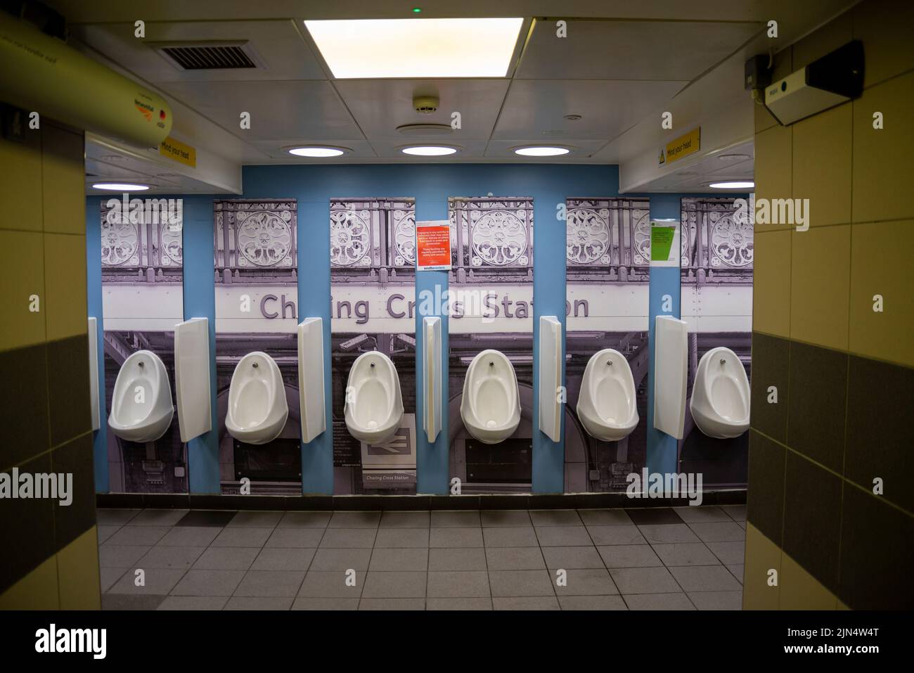 Reihe von Urinalen in Charing Cross Station. Herren-WC im Bahnhof Charing Cross mit detailliertem Foto-Backsplash Stockfoto