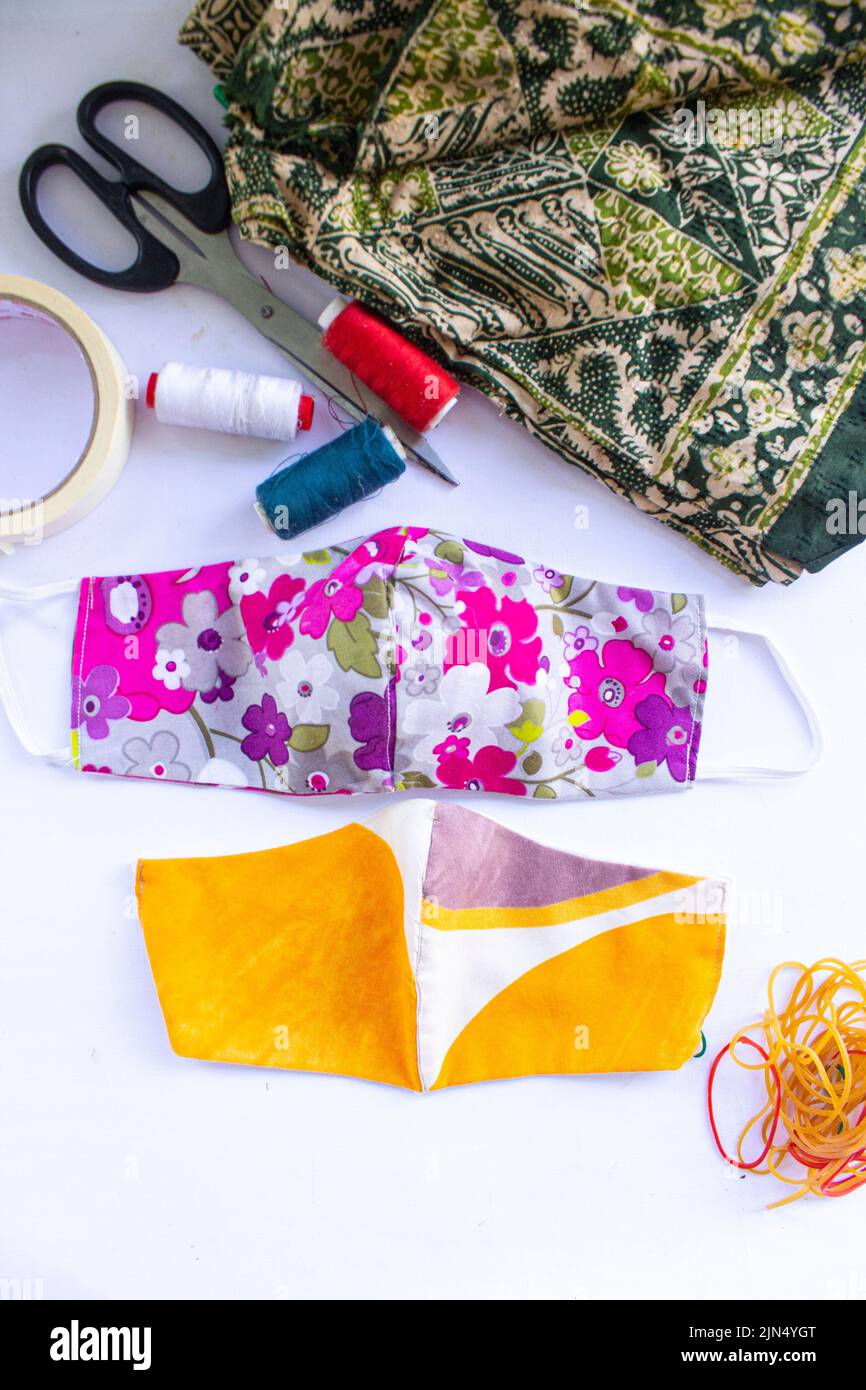 Stoff Maske oder Stoff Gesichtsmaske mit Baumwollstoff Blumenmuster handgefertigten Kunsthandwerk isoliert auf weißem Hintergrund. Diese hygienische Maske für Deckelmund und Stockfoto
