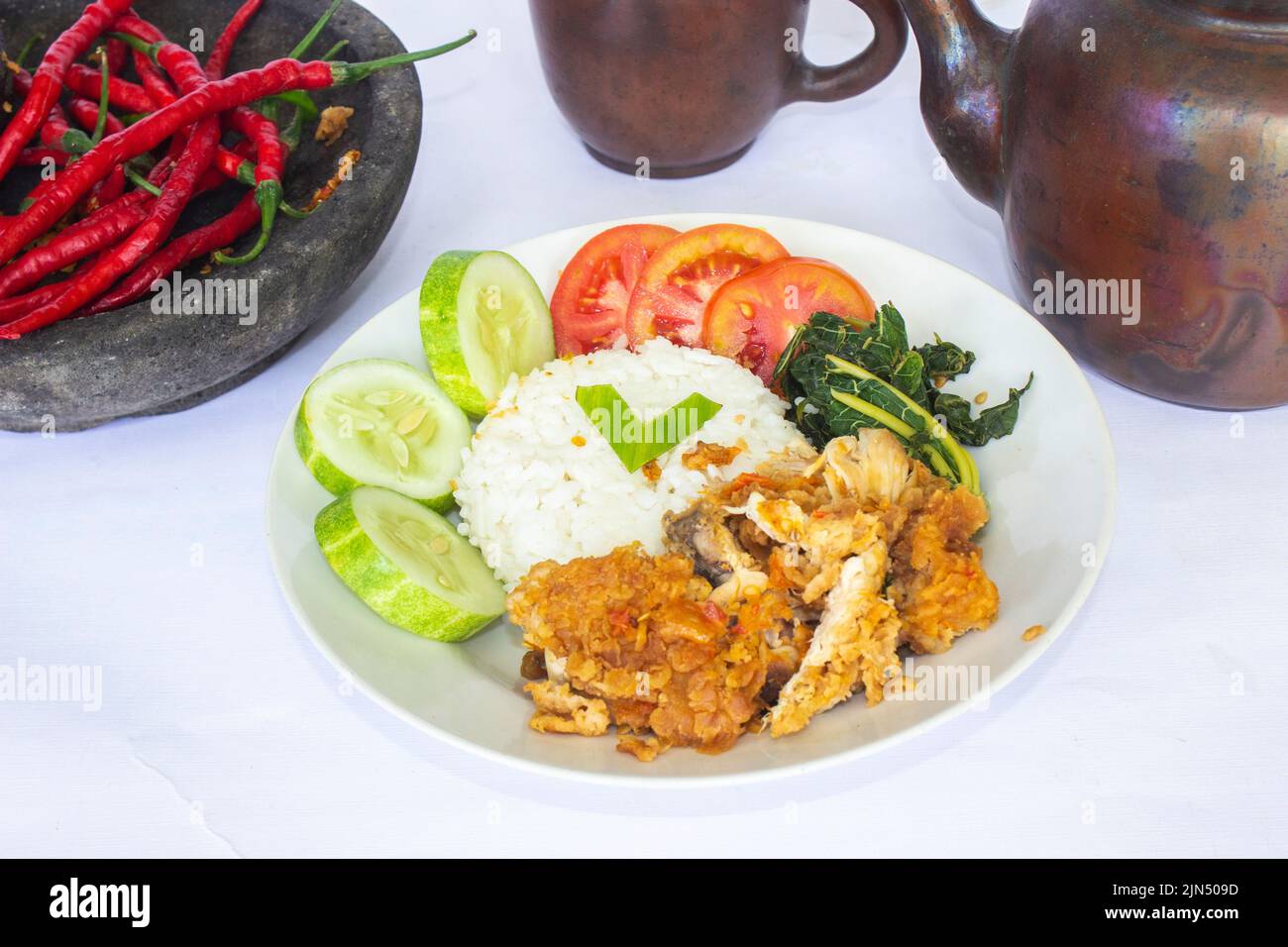 ayam getrek oder Chicken Crush oder Chicken Smashed ist indonesisches Essen aus gebratenem Huhn, das mit Chili und Knoblauch gewürzt und serviert wird Stockfoto