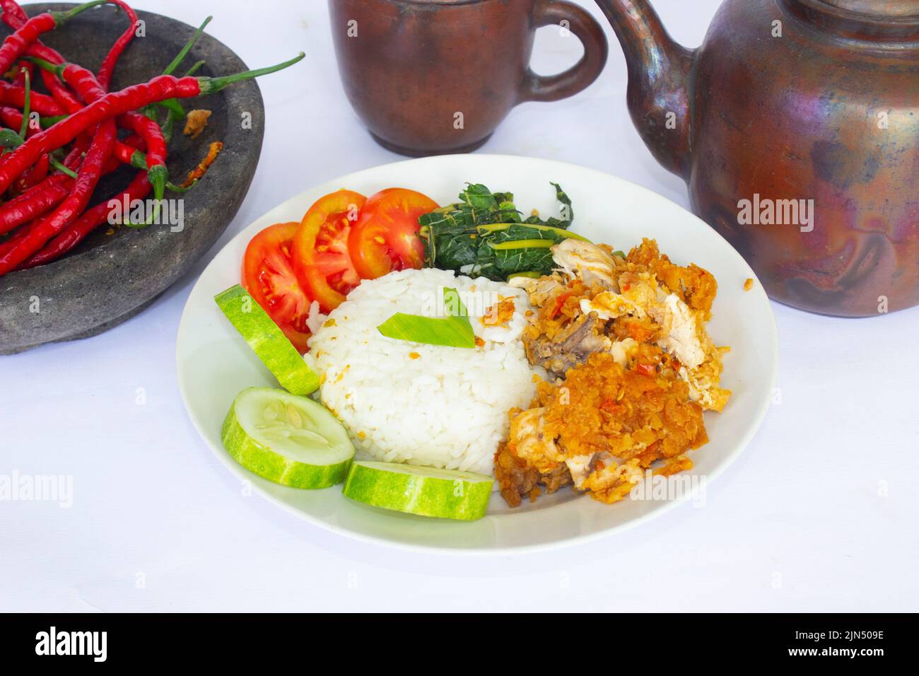 ayam getrek oder Chicken Crush oder Chicken Smashed ist indonesisches Essen aus gebratenem Huhn, das mit Chili und Knoblauch gewürzt und serviert wird Stockfoto