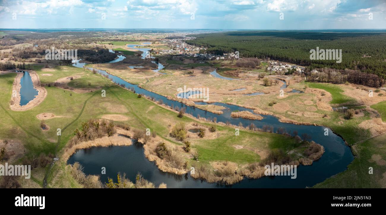 Frühling Luftpanorama Ansicht auf grünen Fluss Delta Tal von Drohne. Region Smijewski auf dem Fluss Siwerskyi Donez in der Ukraine. Flusskurve unter Wolken Stockfoto