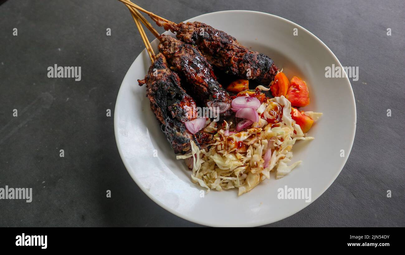 Satagebuntel oder Satagebuntel wird aus gehacktem Hammelfleisch hergestellt, das in Hammelfett eingewickelt und dann gegrillt wird. Würze mit Tomaten, Schalotten, Pfeffer, Cabbag Stockfoto