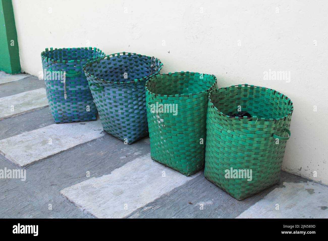 Korb, Plastikkorb dient als Mülleimer.Mülleimer kann draußen gegen die Wand Stockfoto