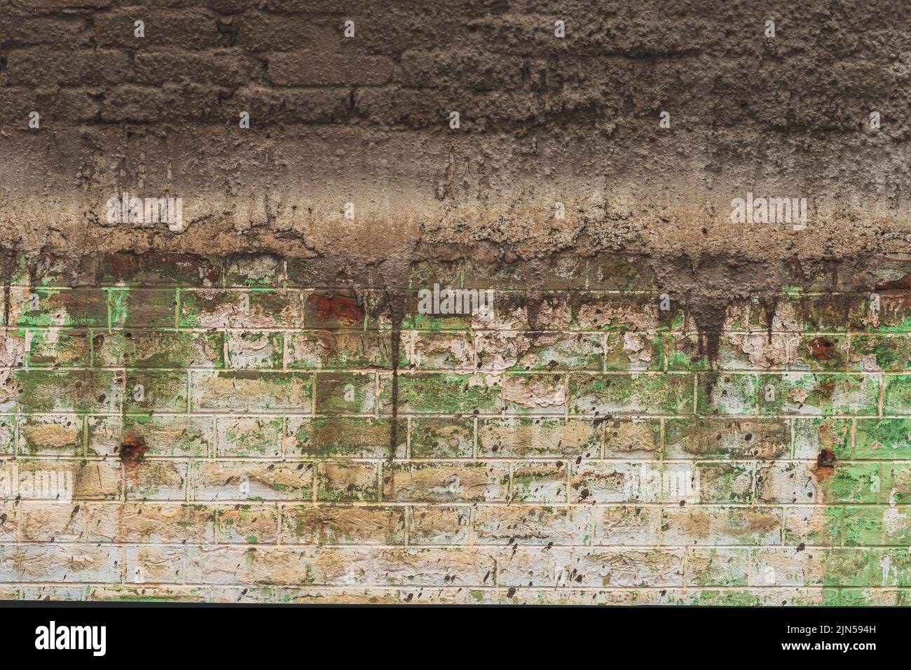 Alte Backsteinmauer mit rauer Zementmörtelabdeckung als Hintergrund Stockfoto