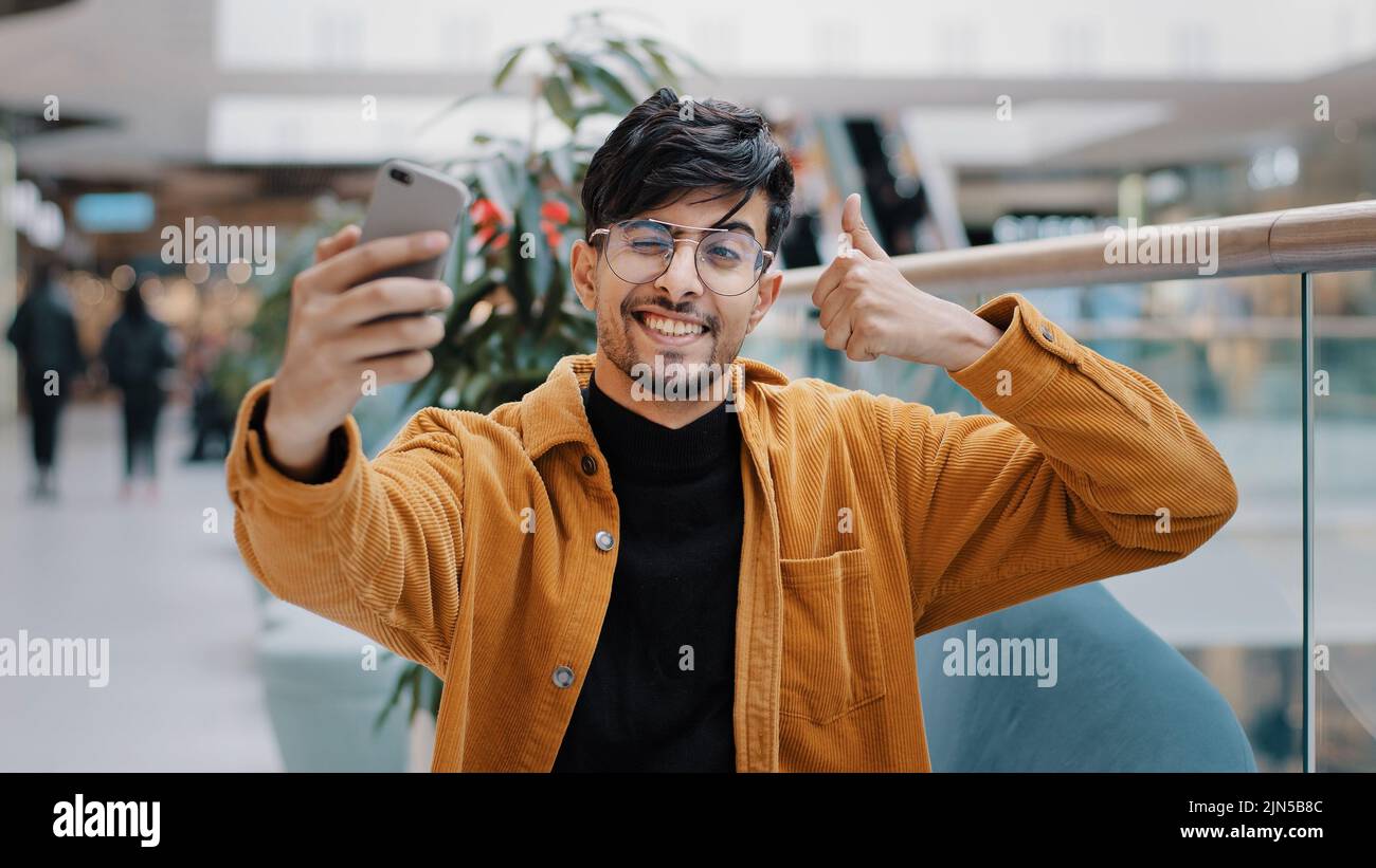 Junge gutaussehende arabischen Kerl Blogger Modell hält Telefon in der Hand auf Handy-Kamera posiert lächelnd macht Geste Aufnahme Foto Filmen Video für fotografiert Stockfoto