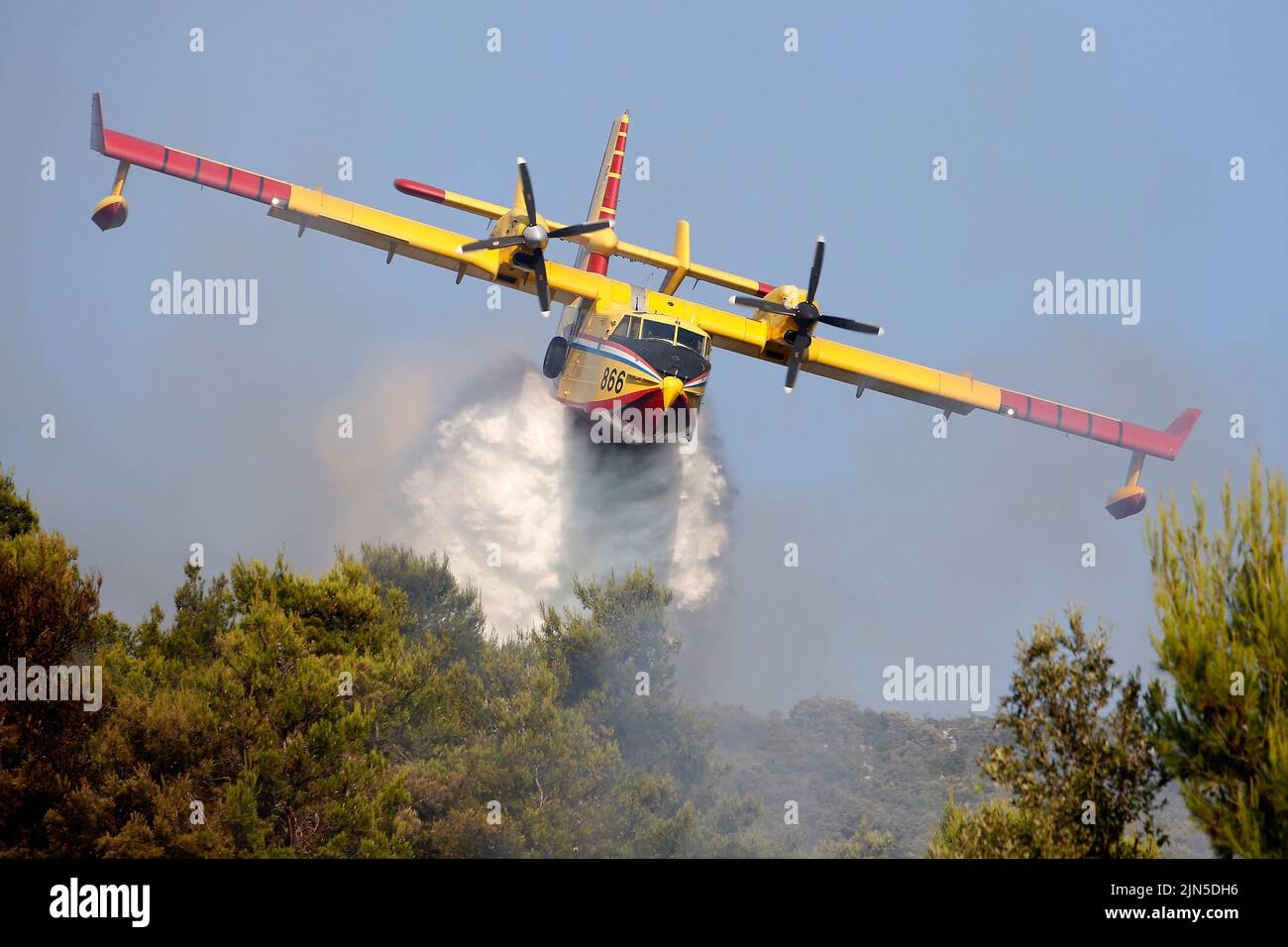 Die kroatische Luftwaffe Canadair CL-415 gibt Wasser frei, während sie einen Brand während eines Waldbrands auf der Halbinsel Peljesec im Süden Kroatiens löscht. Stockfoto