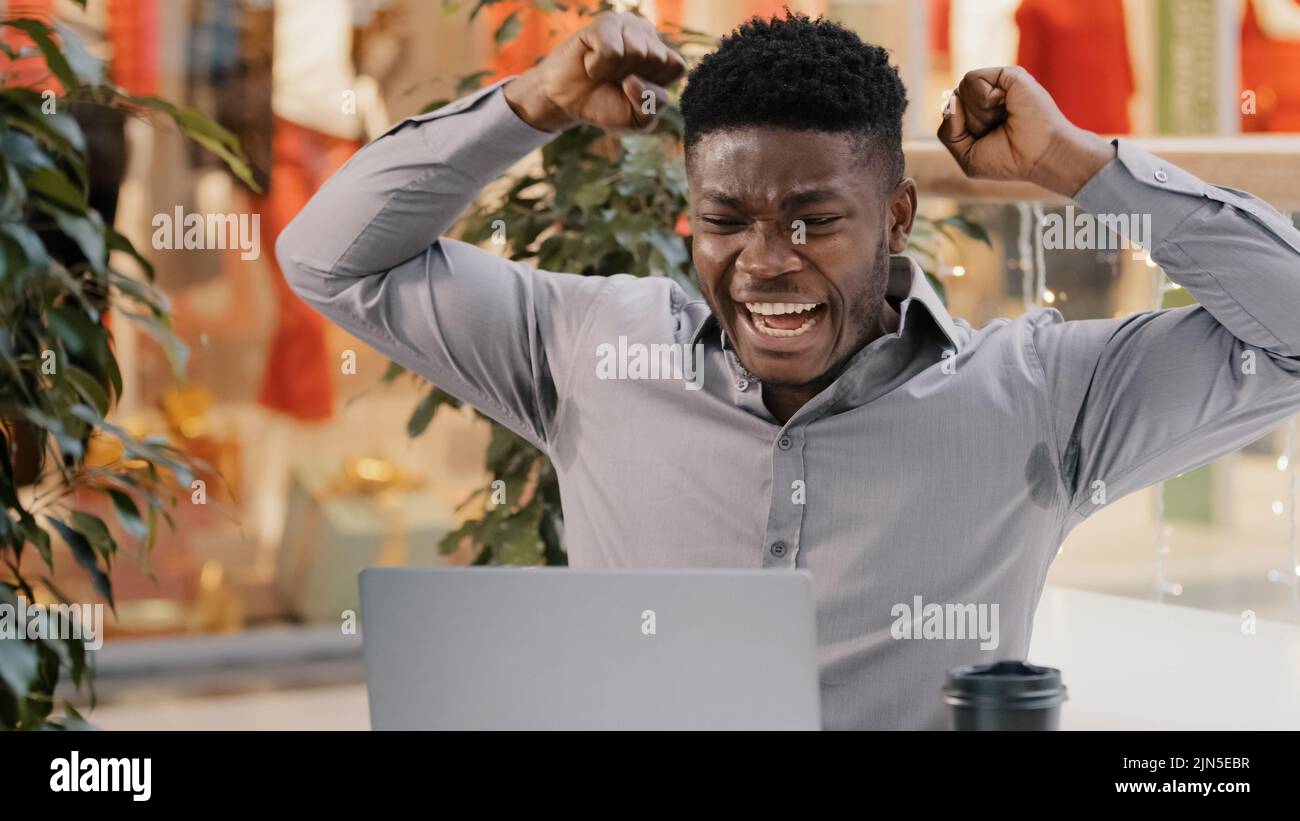 Nahaufnahme junger begeisterter Geschäftsmann liest gute Nachrichten per E-Mail auf Laptop Stauned Happy Guy Gewinner feiert Sieg feiern Erfolg fühlt sich Freude zu gewinnen Stockfoto