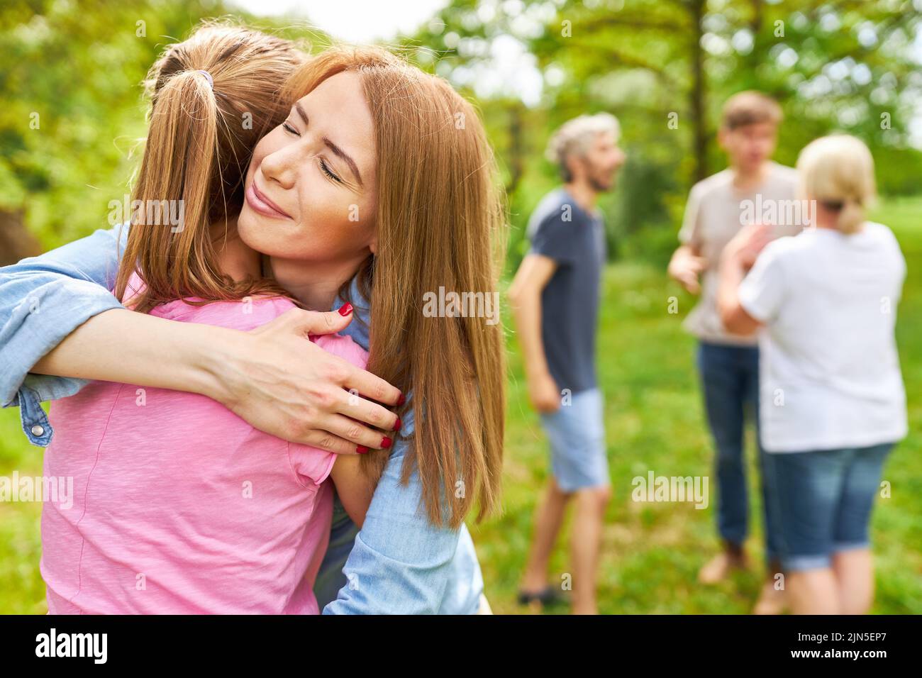 Zwei Frauen als Freundinnen umarmen sich glücklich und voller Dankbarkeit beim Teamevent Stockfoto