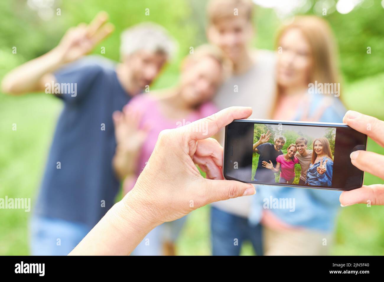 Hände halten das Smartphone, um Freunde oder Familie im Urlaub zu schnappen Stockfoto