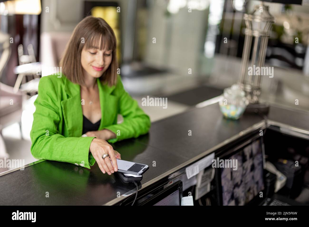 Geschäftsfrau zahlt an der Hotelrezeption Stockfoto