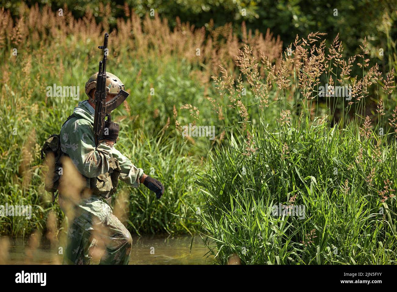 Volle militärische Erfahrung - eines Tages Kommando - läuft durch das Wasser mit automatischen Gewehr Replik Stockfoto