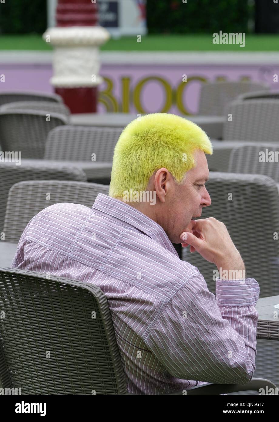 Blackpool, Lancashire, UK August 6 2022 Ein nüchtern aussehender Herr mit leuchtend gelben Haaren wartet geduldig auf das Blackpool Rebellion Punk Festival Stockfoto