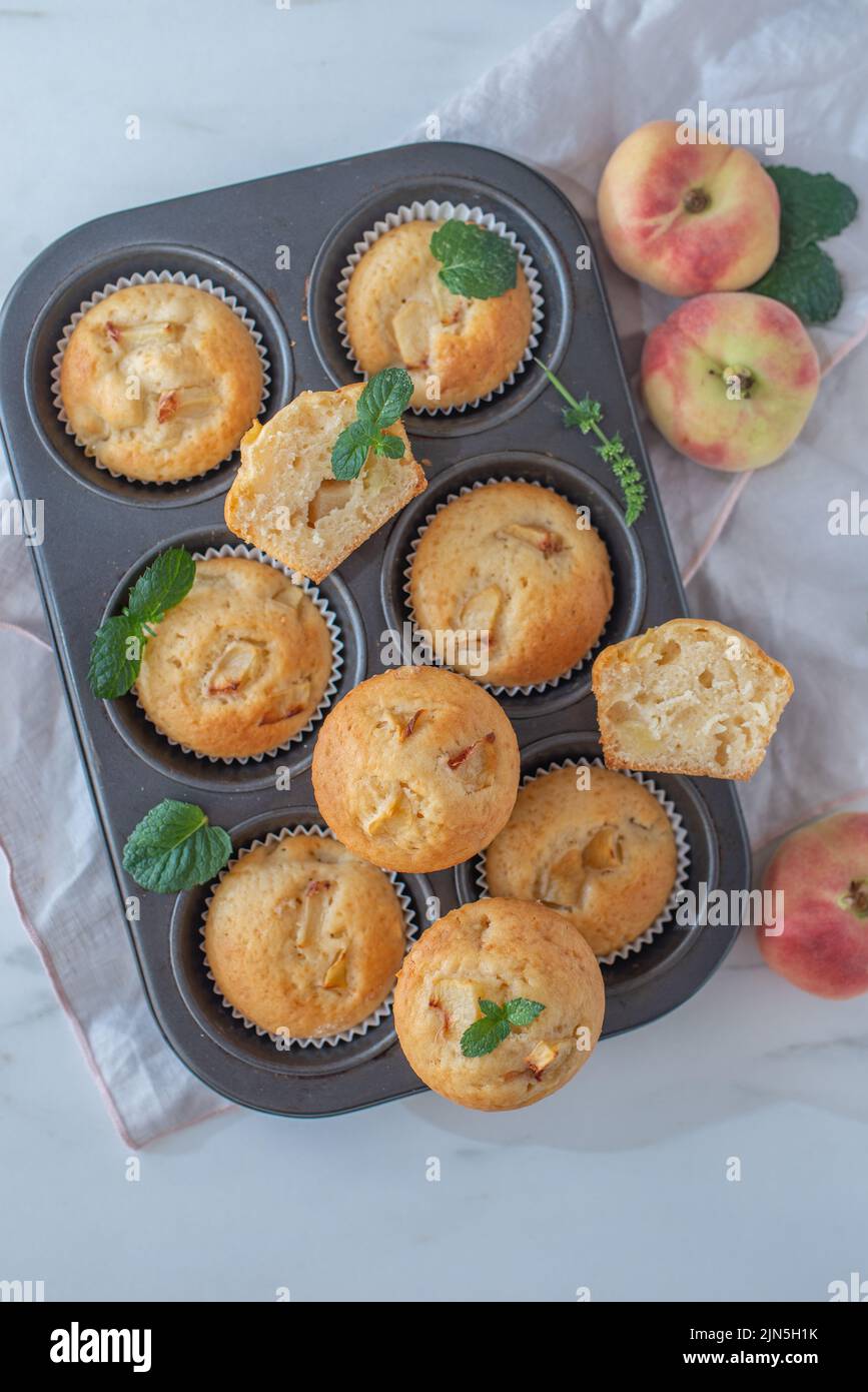Süße hausgemachte Vanillepfirsich-Muffins auf einem Tisch Stockfoto