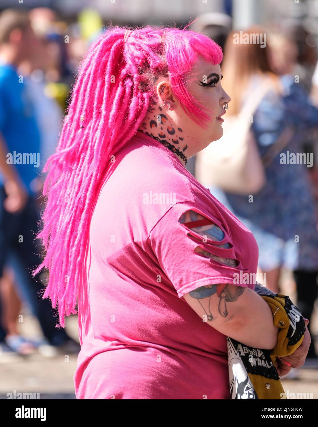 Blackpool, Lancashire, Großbritannien August 6 2022 Seitenansicht einer jungen Frau mit exotischem Make-up und leuchtend rosa Haaren und T-Shirt während der Blackpool Rebellion Stockfoto