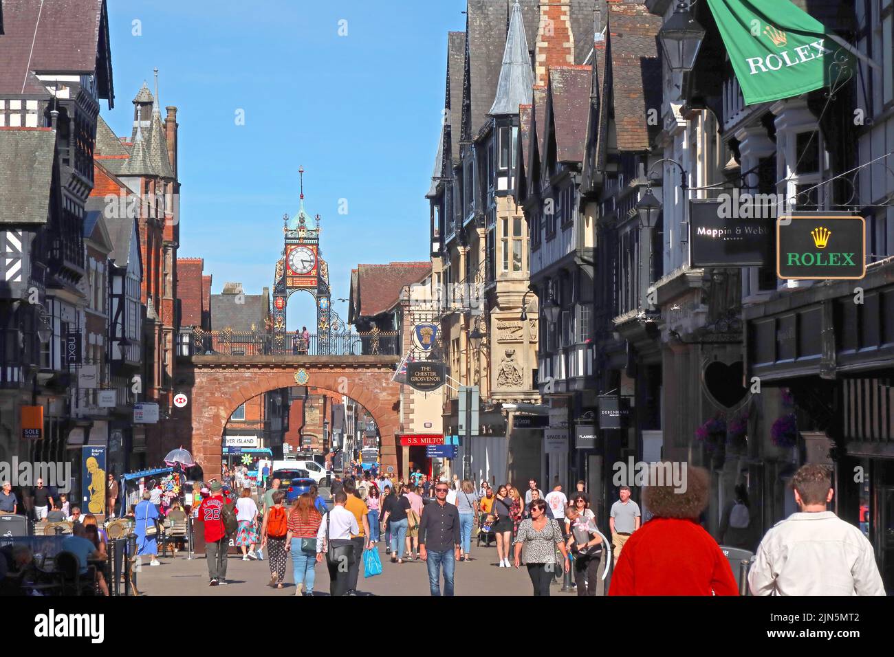 Ein geschäftiger Sommertag, Eastgate mit einer viktorianischen Turmuhr aus dem Jahr 1897 und Stadtmauern Georgian Arch Bridge, Chester, Cheshire, England, Großbritannien, CH1 1LE Stockfoto