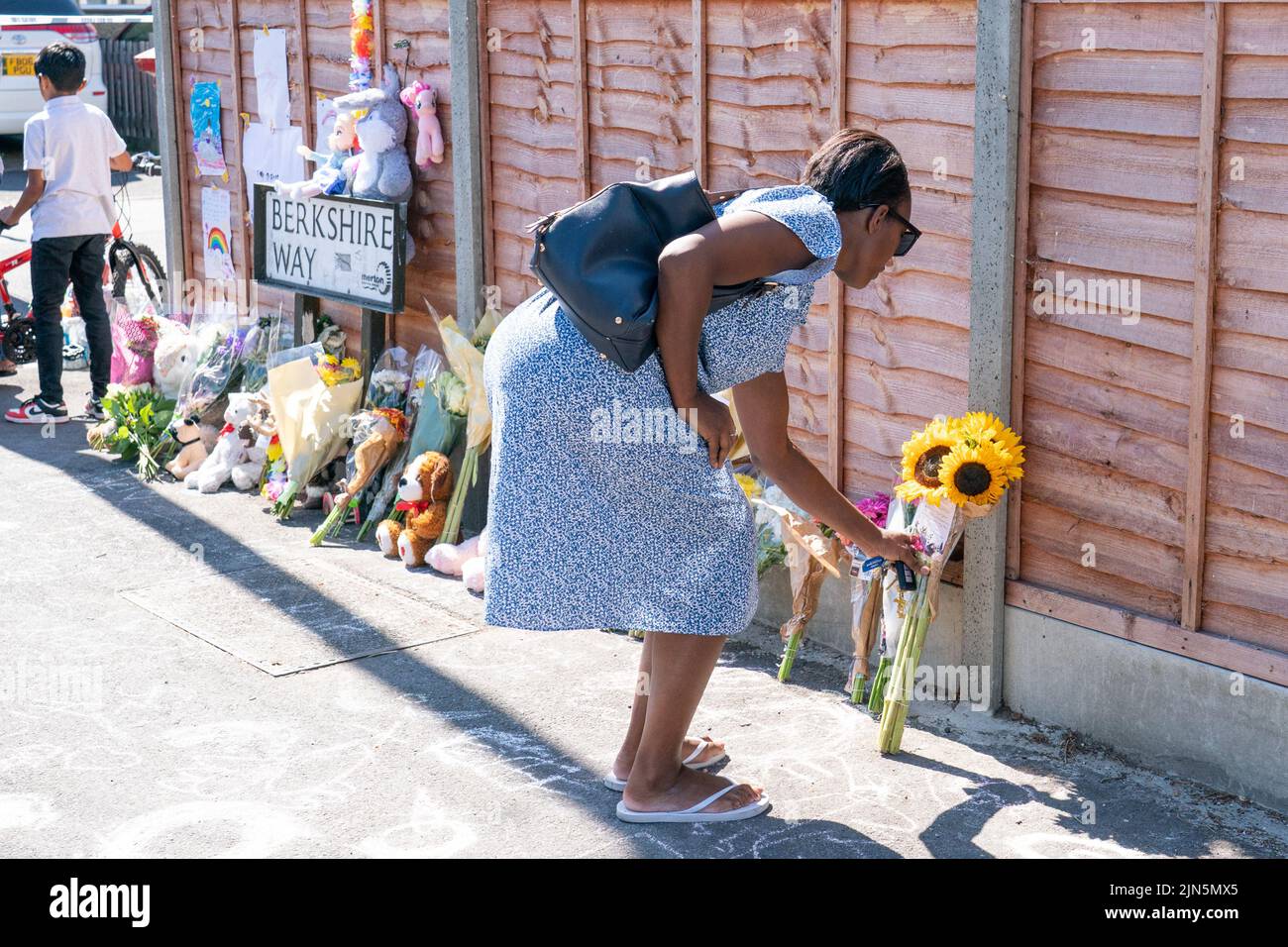 Eine Frau legt Blumen in der Nähe von Galpin's Road in Thornton Heath, im Süden Londons. Der Londoner Krankenwagen hat bestätigt, dass ein Kind gestorben ist und drei Personen im Krankenhaus sind, nachdem das Reihenhaus am Montag nach einer Explosion und einem Brand zusammengebrochen war. Bilddatum: Dienstag, 9. August 2022. Stockfoto