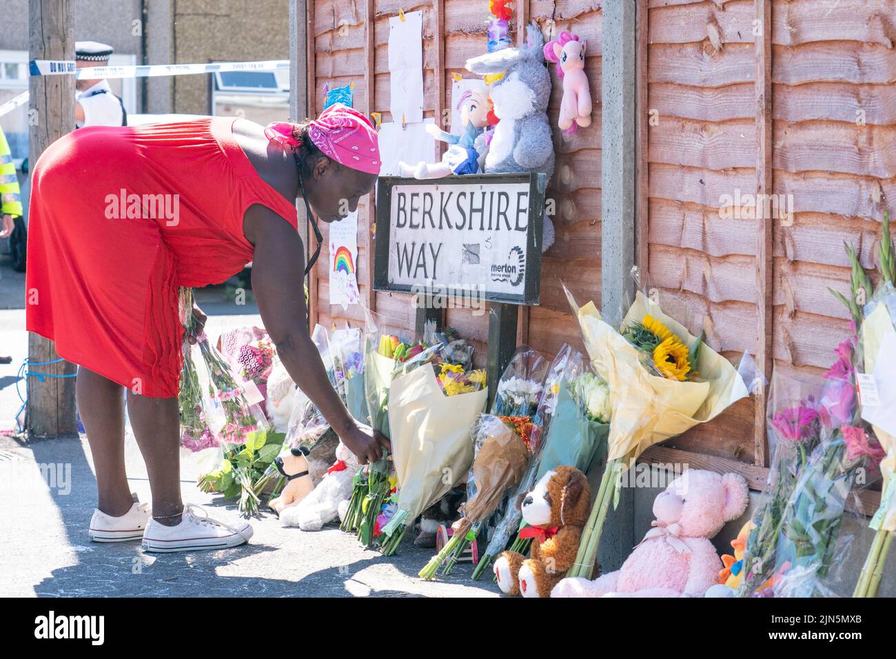 Eine Frau legt Blumen in der Nähe von Galpin's Road in Thornton Heath, im Süden Londons. Der Londoner Krankenwagen hat bestätigt, dass ein Kind gestorben ist und drei Personen im Krankenhaus sind, nachdem das Reihenhaus am Montag nach einer Explosion und einem Brand zusammengebrochen war. Bilddatum: Dienstag, 9. August 2022. Stockfoto