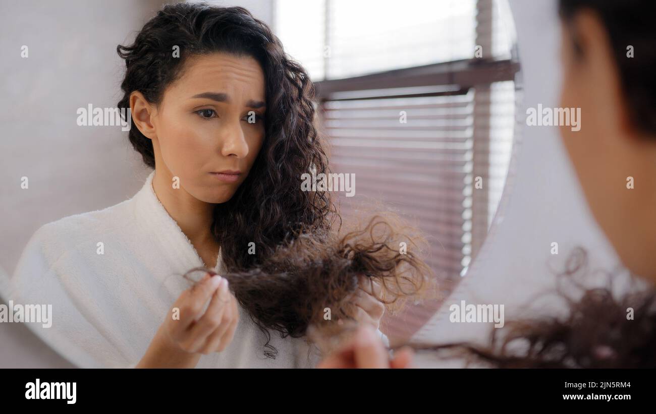 Verärgert traurig junge Frau von geschädigtem Haar verzweifelt frustriert über Spliss Mädchen besorgt über Verlust brüchiges trockenes Haar Hormon Problem Vitamin Stockfoto