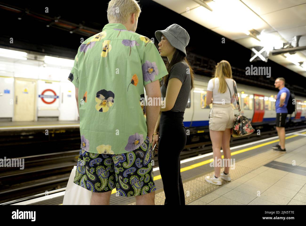 London, England, Großbritannien. Menschen, die auf dem Bahnsteig einer U-Bahn-Station warten Stockfoto