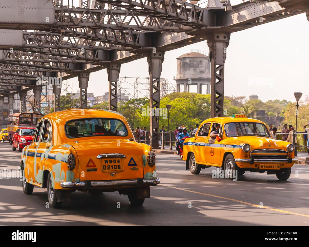 Alte Hindustan Ambassador-Taxis fahren über die erste Hooghly-Brücke in Kalkutta/Kalkata, auch bekannt als Rabindra Setu. Stockfoto