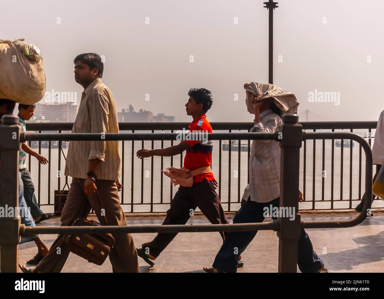 Gewöhnliche Menschen, Tagelöhner und Arbeiter gehen über die erste Hooghly-Brücke in Kalkutta / Kalkutta, auch bekannt als Rabindra Setu. Stockfoto