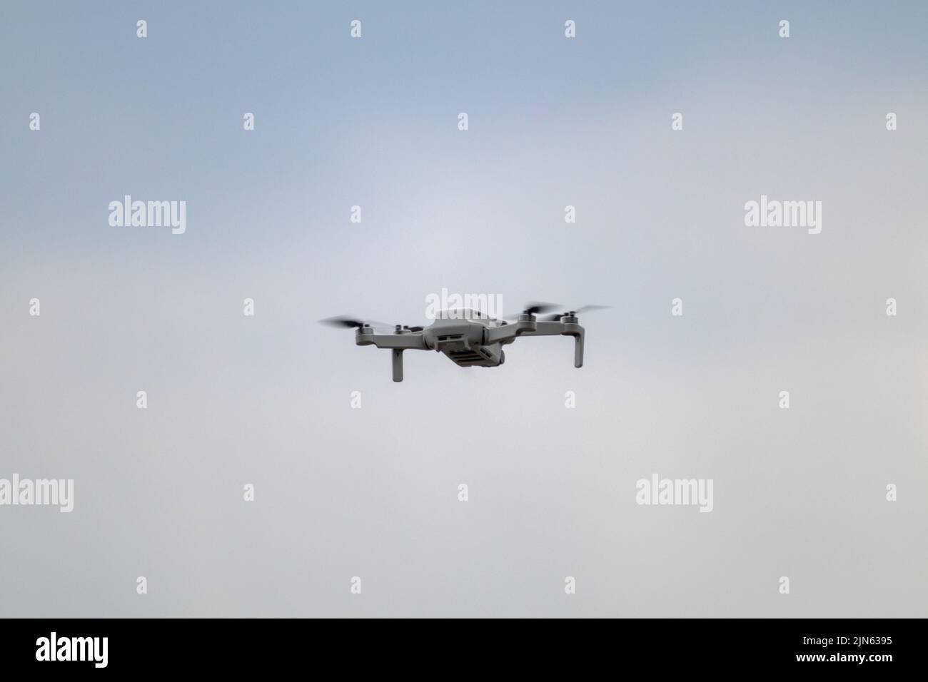 Kharkiv, Ukraine - 22. April 2021: DJI Mavic Mini 2 Drohne fliegt, Rückansicht. Quadcopter-Gerät schwebt auf grau bewölktem Himmel Hintergrund Stockfoto