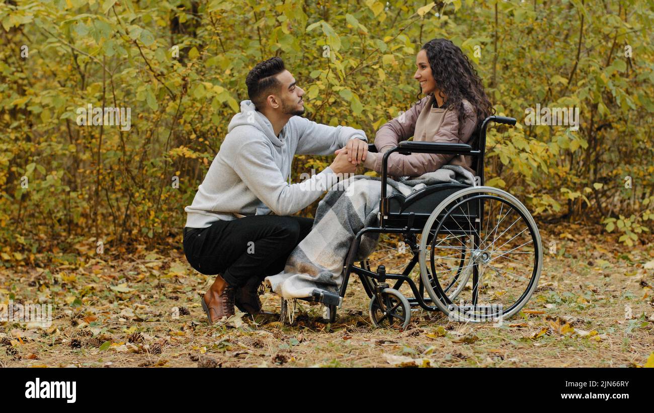 Junge glücklich hispanischen Paar in der Liebe mit niedlichen Gespräch Gespräch fürsorglich Freund besucht kranke Freundin im Krankenhaus Park Frau Patient in Stockfoto
