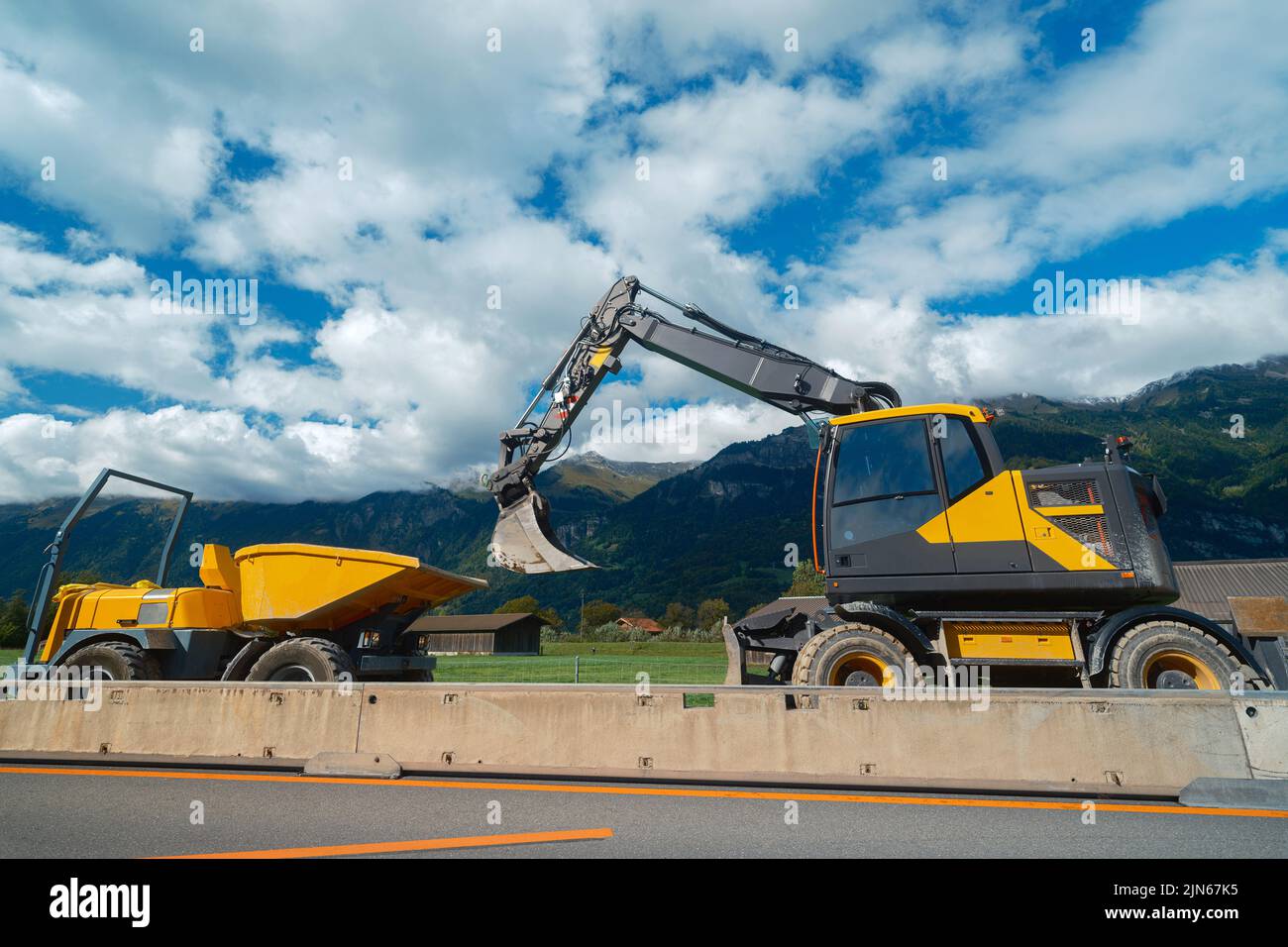 Gelber mittelgroßer Radbagger mit Mini-Dumper Stockfoto
