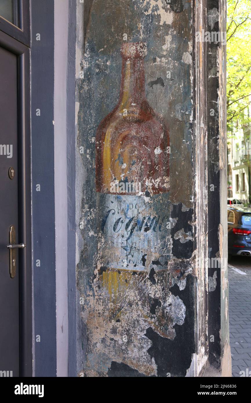 Krakau. Krakau. Polen. Eine Flasche Cognac, eine alte, an der Außenwand gestrichene Werbung für ein ehemaliges Restaurant. Stockfoto
