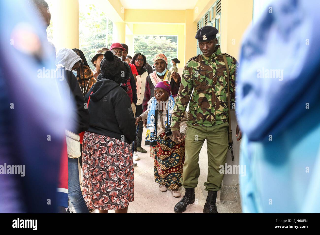 Nakuru, Kenia. 09. August 2022. Der Polizeibeamte Gilbert Langat, 32 (R), hilft Esther Thira, 77 (R2), Während der Parlamentswahlen in Kenia können Sie das Wahlgebiet der Nakuru Boys High School im Wahlkreis Nakuru Town East besuchen. Die Kenianer haben am Dienstagmorgen, dem 9. August 2022, mit der Wahl ihres bevorzugten Präsidenten und der Mitglieder der nationalen und der Bezirksversammlungen begonnen. (Foto von James Wakibia/SOPA Images/Sipa USA) Quelle: SIPA USA/Alamy Live News Stockfoto