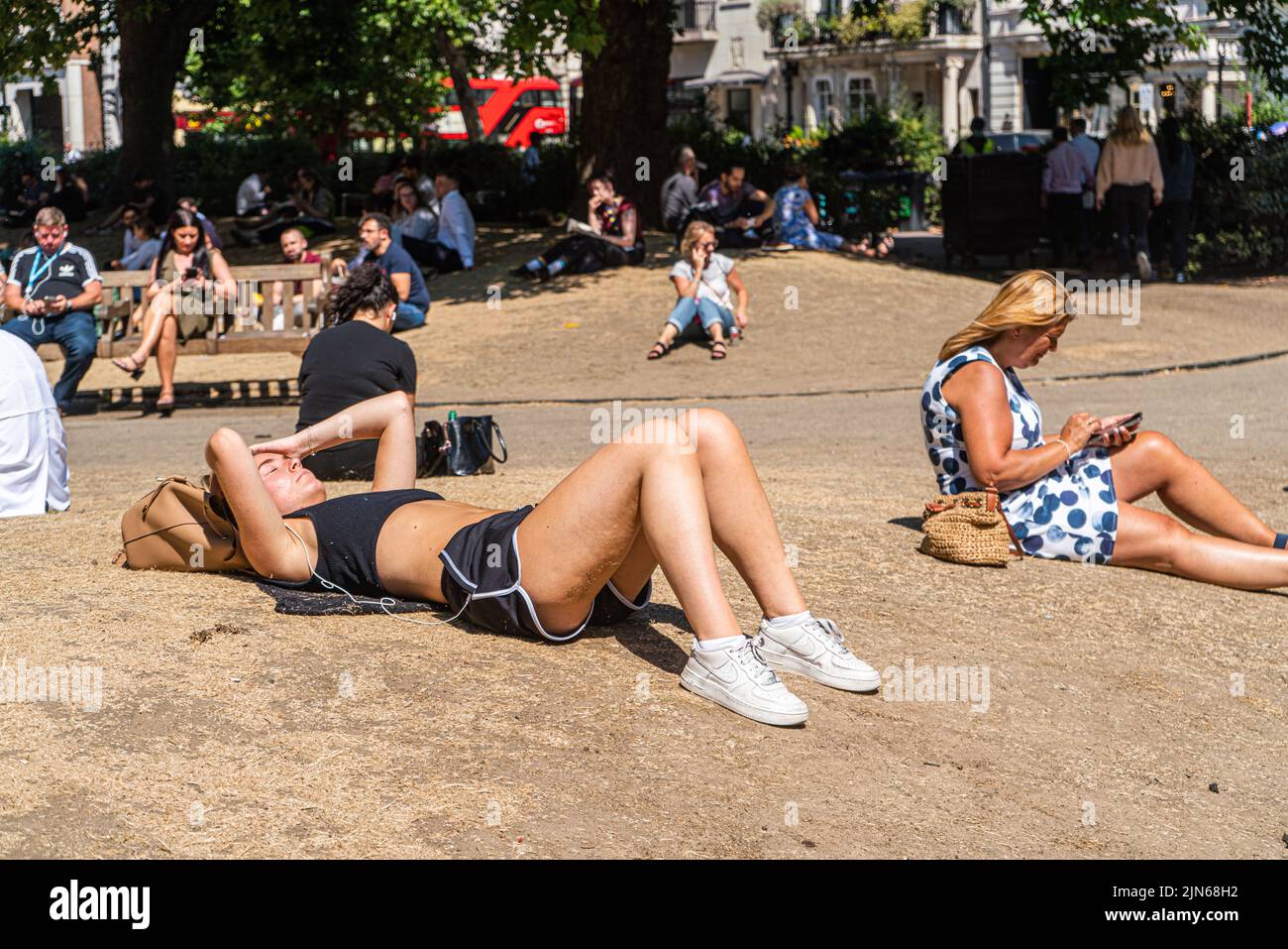 London, Großbritannien. 9. August 2022 Büroangestellte genießen die Sonne auf dem ausgetrocknten Gras am Cavendish Square London. Die britische Gesundheitsbehörde hat eine Warnung ausgegeben, da England auf einem Niveau von 3 Gesundheitswarnungen gesetzt wird, die voraussichtlich in der nächsten Woche auf Mitte 30 Grad celsius steigen werden. Kredit. amer Ghazzal/Alamy Live Nachrichten Stockfoto