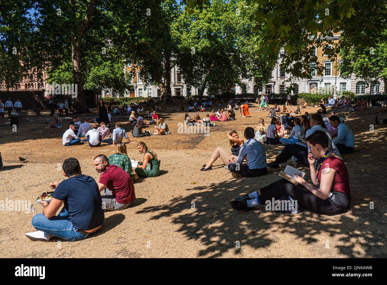 London, Großbritannien. 9. August 2022 Büroangestellte genießen die Sonne auf dem ausgetrocknten Gras am Cavendish Square London. Die britische Gesundheitsbehörde hat eine Warnung ausgegeben, da England auf einem Niveau von 3 Gesundheitswarnungen gesetzt wird, die voraussichtlich in der nächsten Woche auf Mitte 30 Grad celsius steigen werden. Kredit. amer Ghazzal/Alamy Live Nachrichten Stockfoto