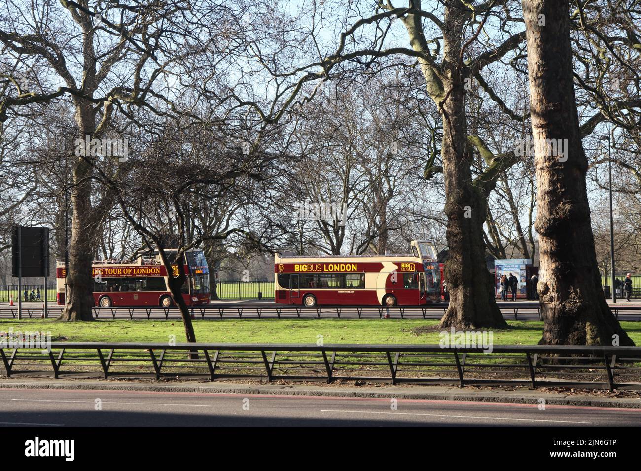 Touristenbusse BIG8BUS LONDON an einem sonnigen Wintertag auf der Park Lane in London in der Nähe des Hyde Park Stockfoto