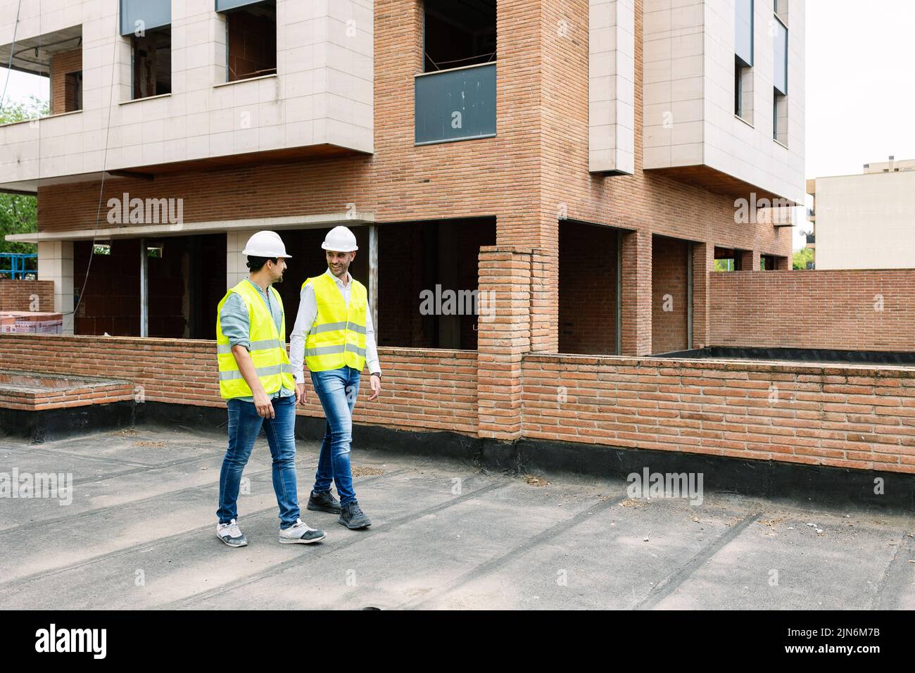 Professionelle Ingenieure entwerfen Arbeiter, die auf der Baustelle reden Stockfoto