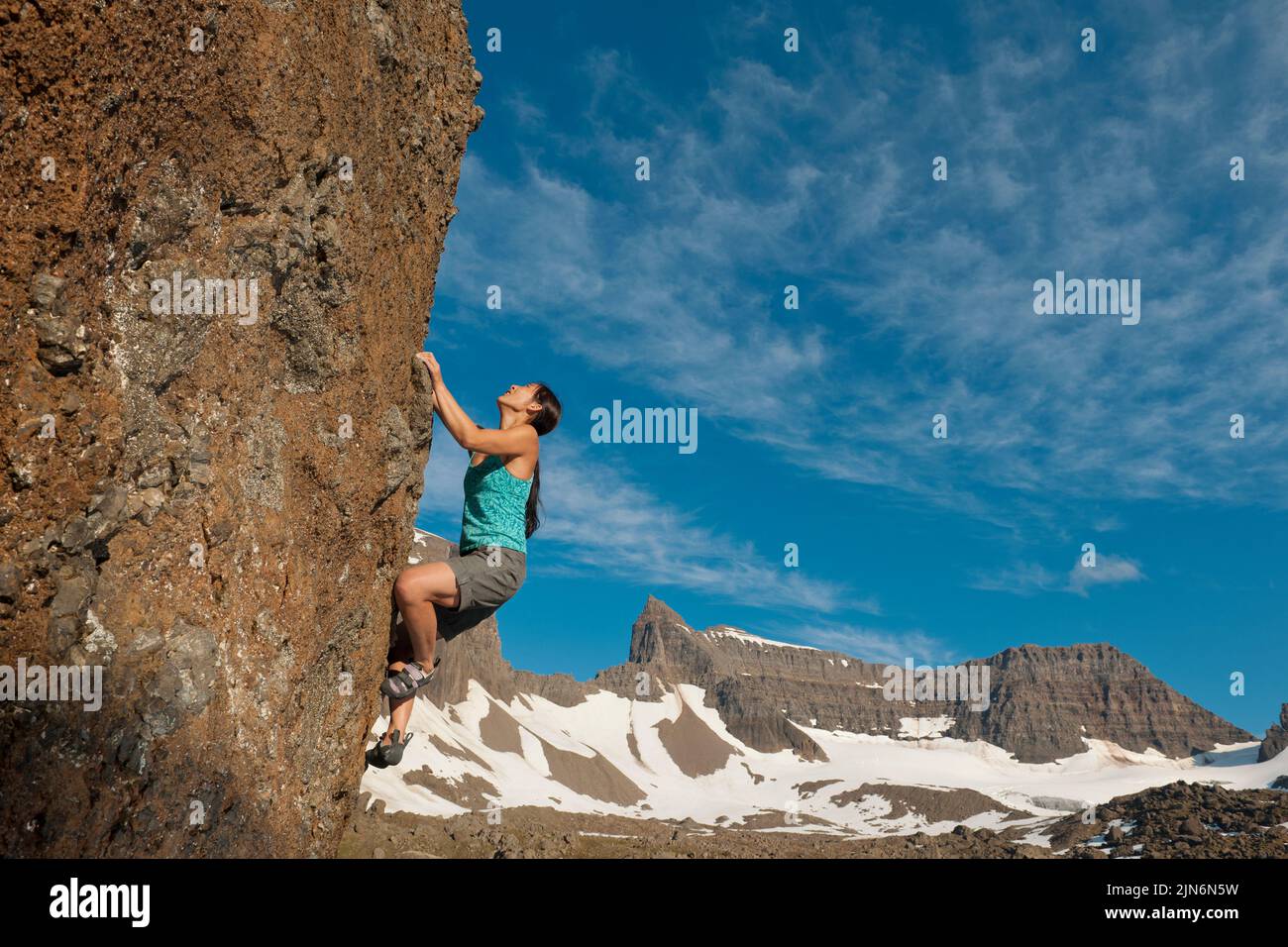 Frau beim Bouldern in den entlegenen östlichen Fjorden Islands Stockfoto