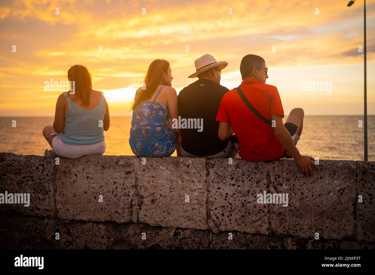 Besucher genießen den Sonnenuntergang von oben auf den Mauern der Altstadt von Cartagena, Kolumbien Stockfoto