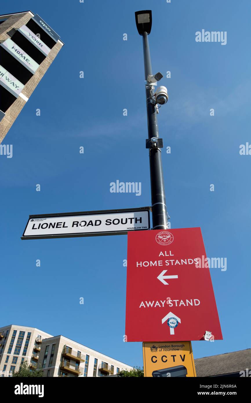 Wegbeschreibungen Schilder, ein Straßennamen-Schild und cctv vor dem gtech-Gemeindestadion, Heimstadion des fußballvereins brentford, in brentford, london, england Stockfoto