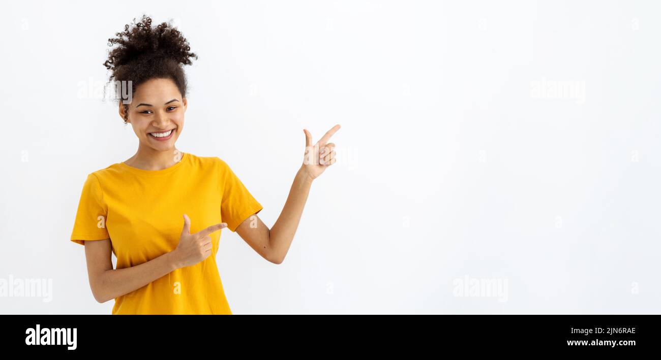 Schöne junge Frau lächelt mit seinem Finger auf einen weißen Hintergrund mit Kopierraum zeigen Stockfoto