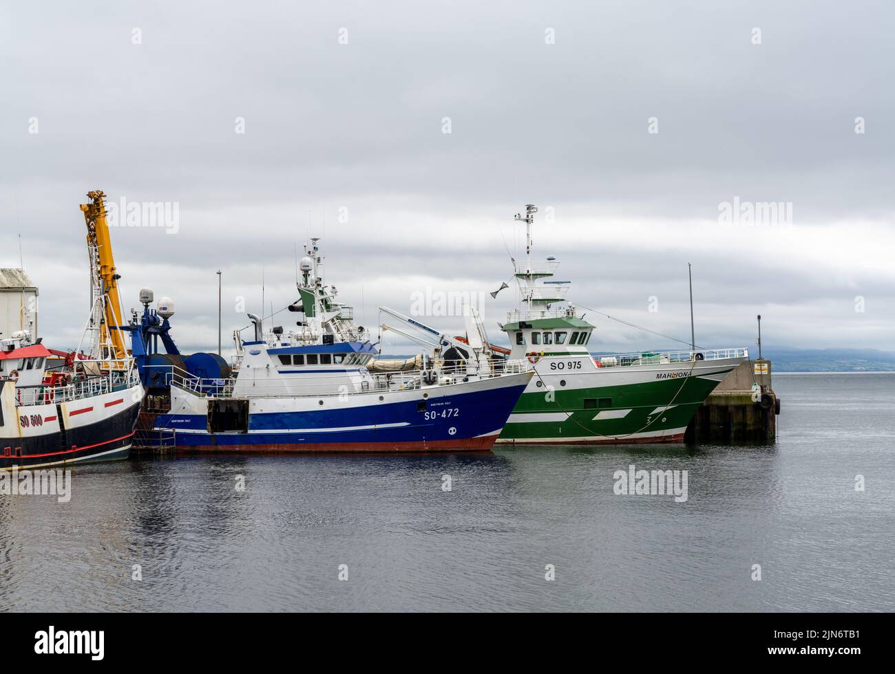 Greencastle, Irland - 9. Juli 2022: Bunte Fischerboote und Trawler im geschützten Hafen und Hafen von Greencastle Stockfoto