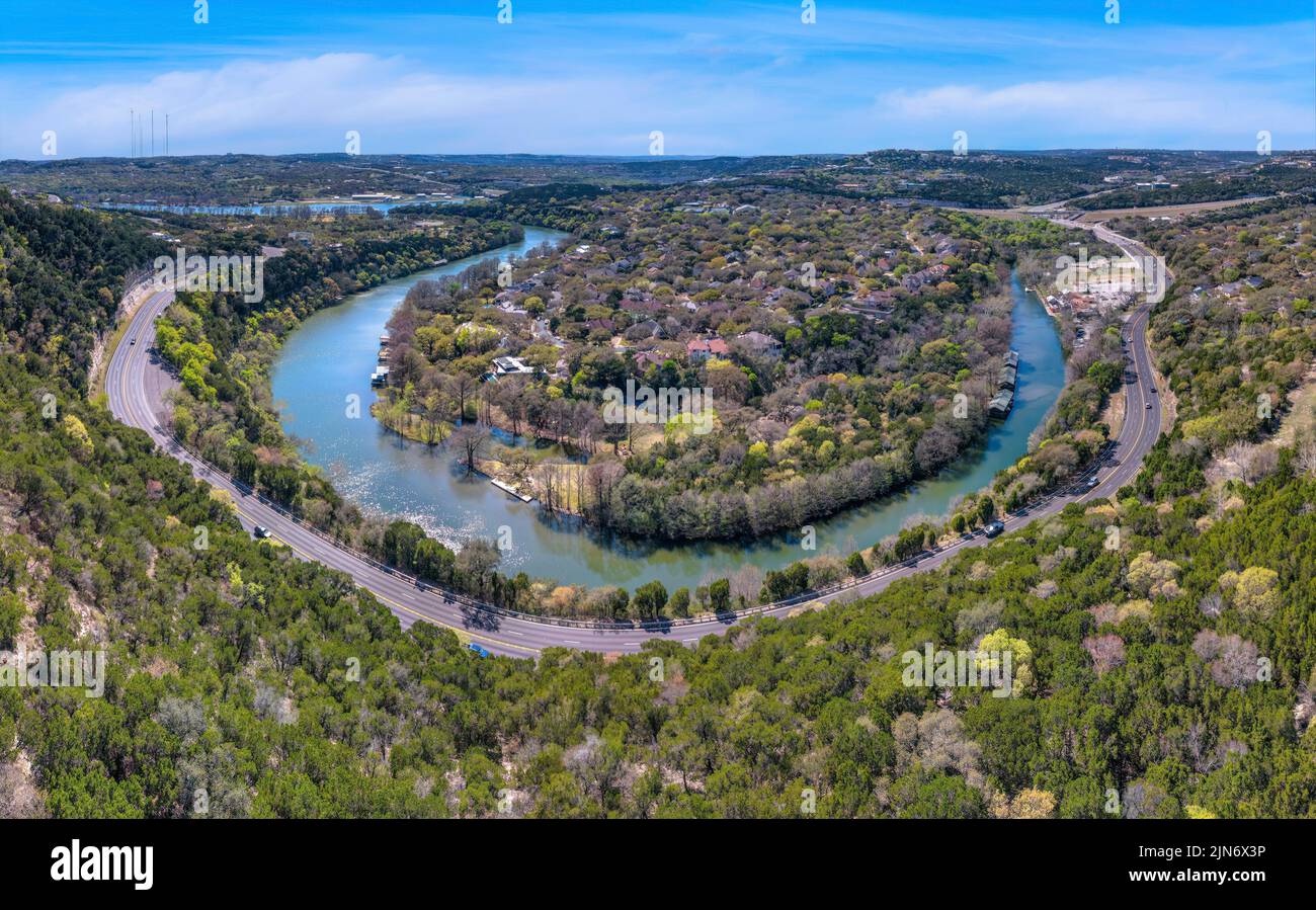 Austin, Texas - Blick von oben auf einen Hang mit Highway unten in der Nähe des Colorado River. In der Mitte des ri befindet sich eine Insel mit Wohnhäusern Stockfoto