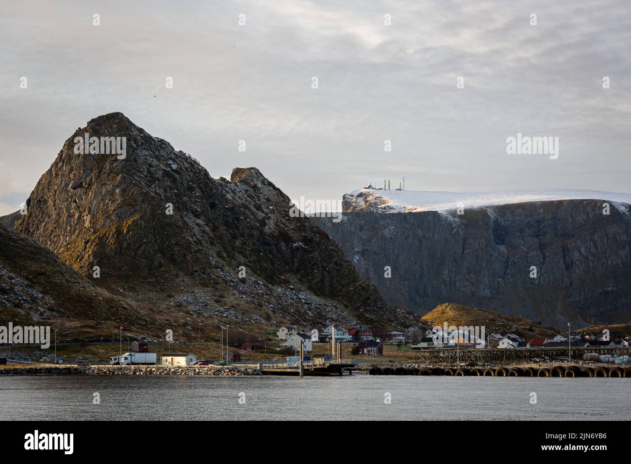 Die kleinen Dorfgebäude vor den Klippen und Bergen am Wasser Stockfoto